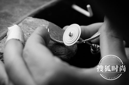 珠宝工匠细心打造手镯上的金质滚珠